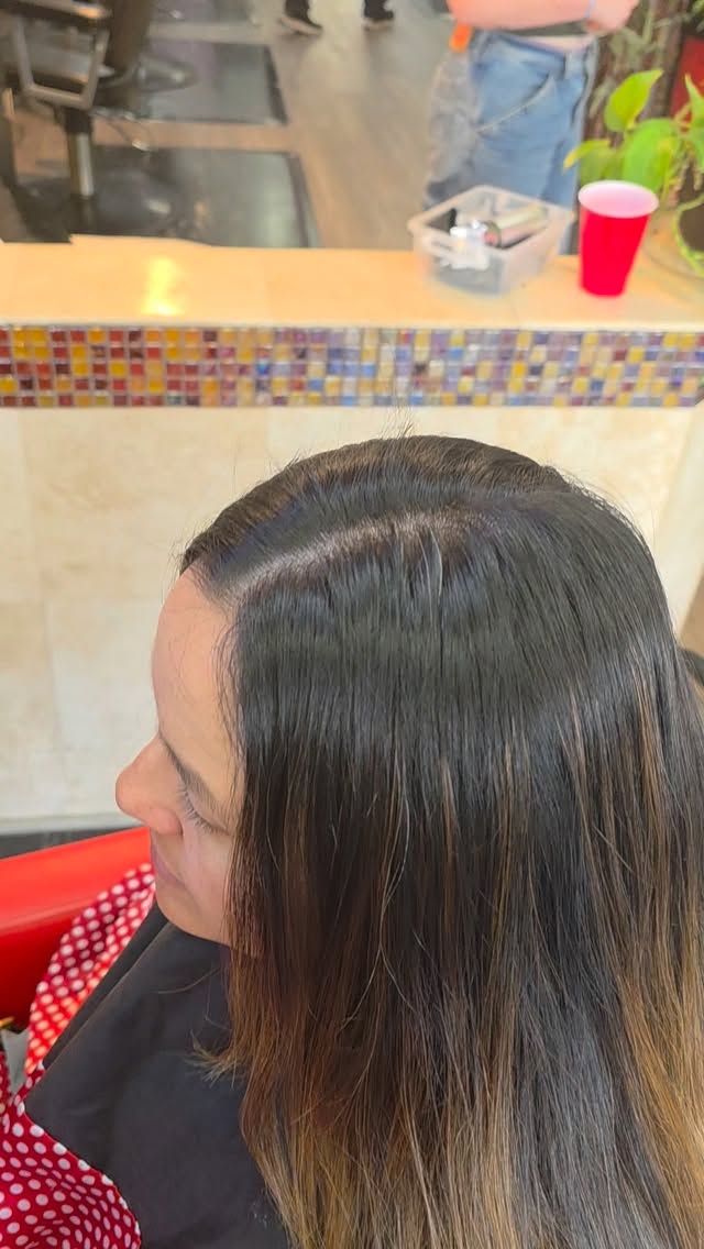 Sleek dark brown hair with subtle balayage styled at Beauty and the Barber