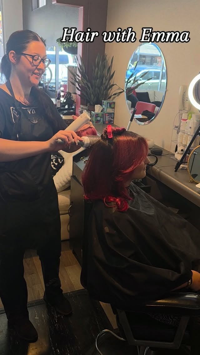 Stylist Emma styling a client vivid red hair