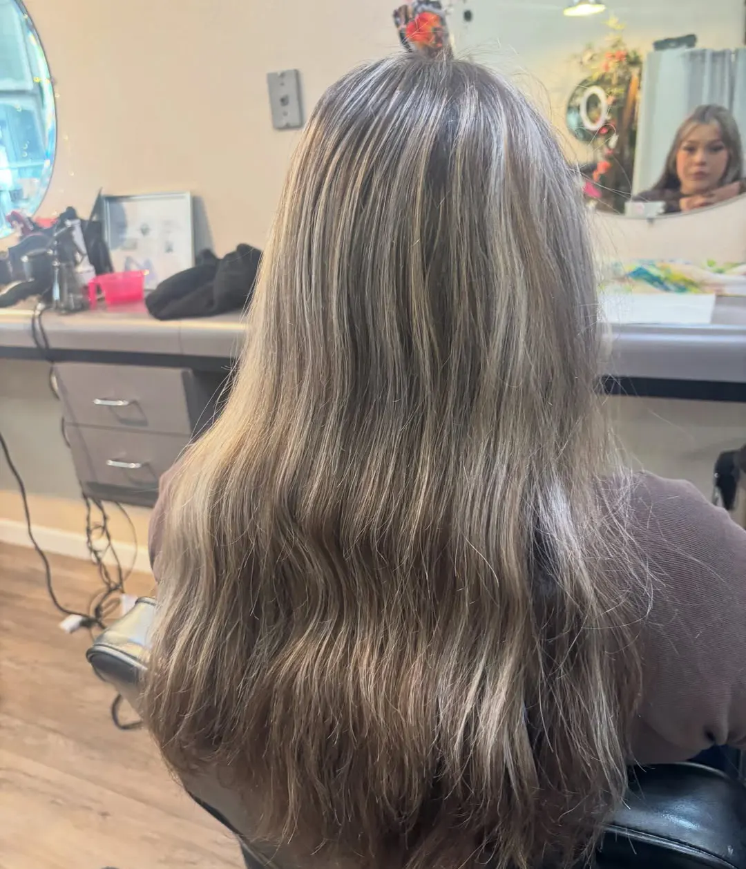 Long ash blonde wavy hair, back view in the salon