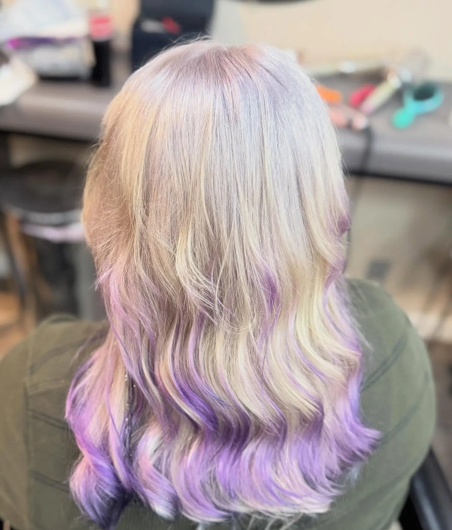 Platinum blonde hair with lilac purple ends, styled in waves