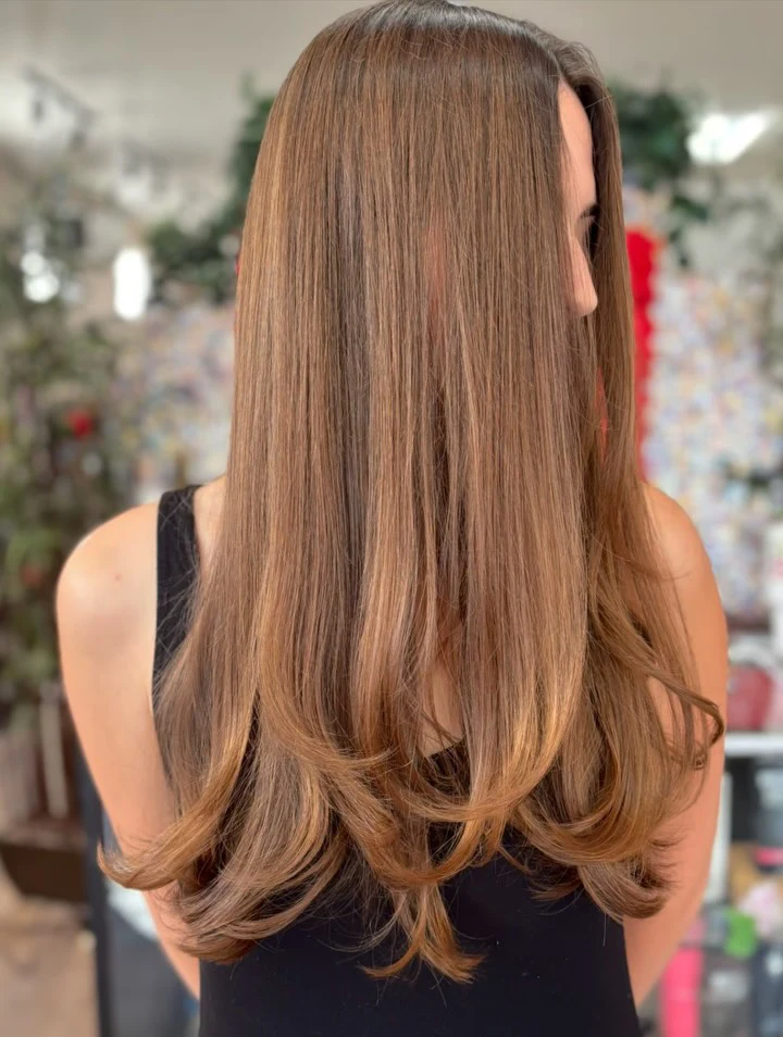 Long caramel balayage, back view in the salon