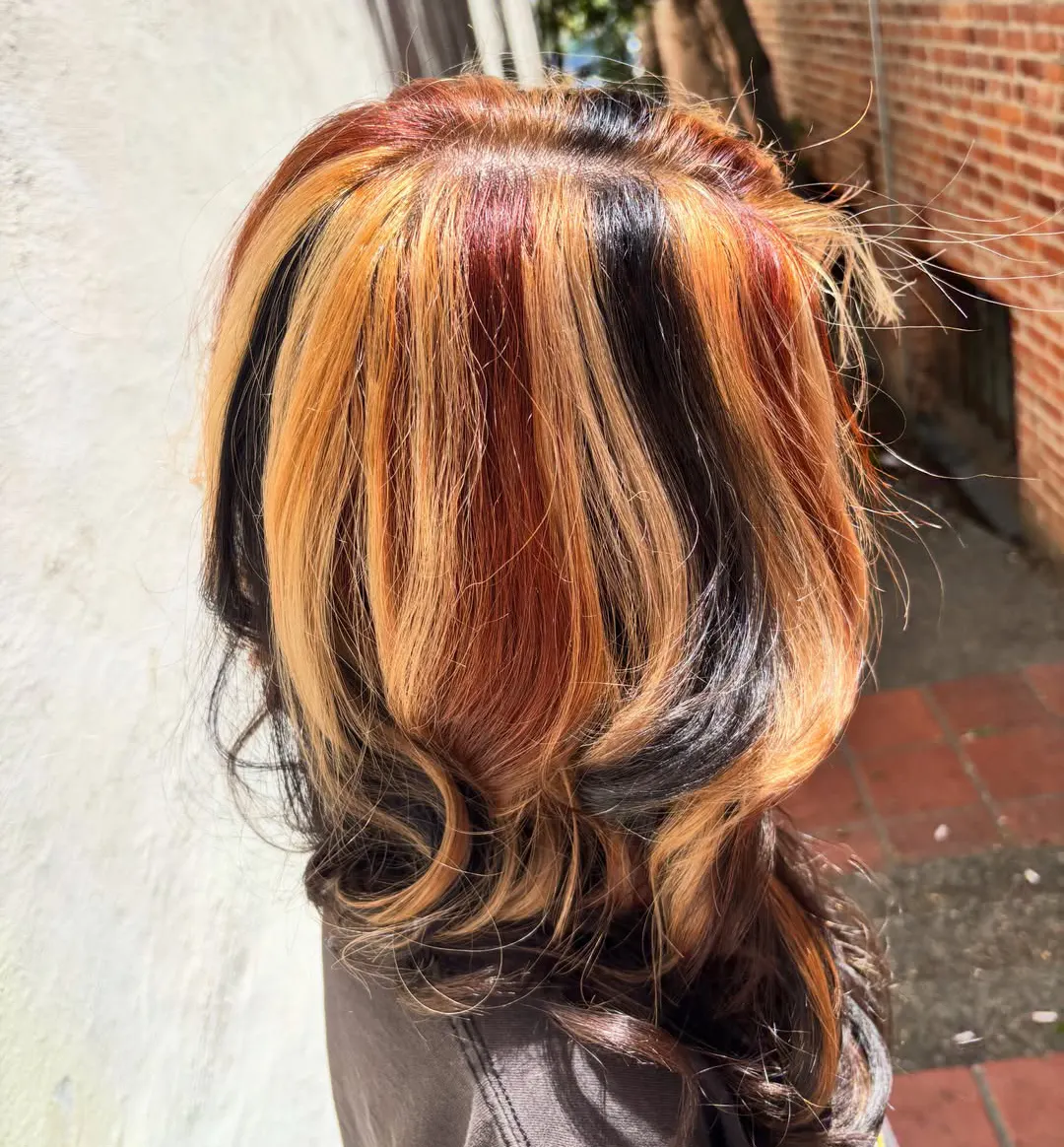 Multi-tone highlights in black, red and blonde, styled in curls
