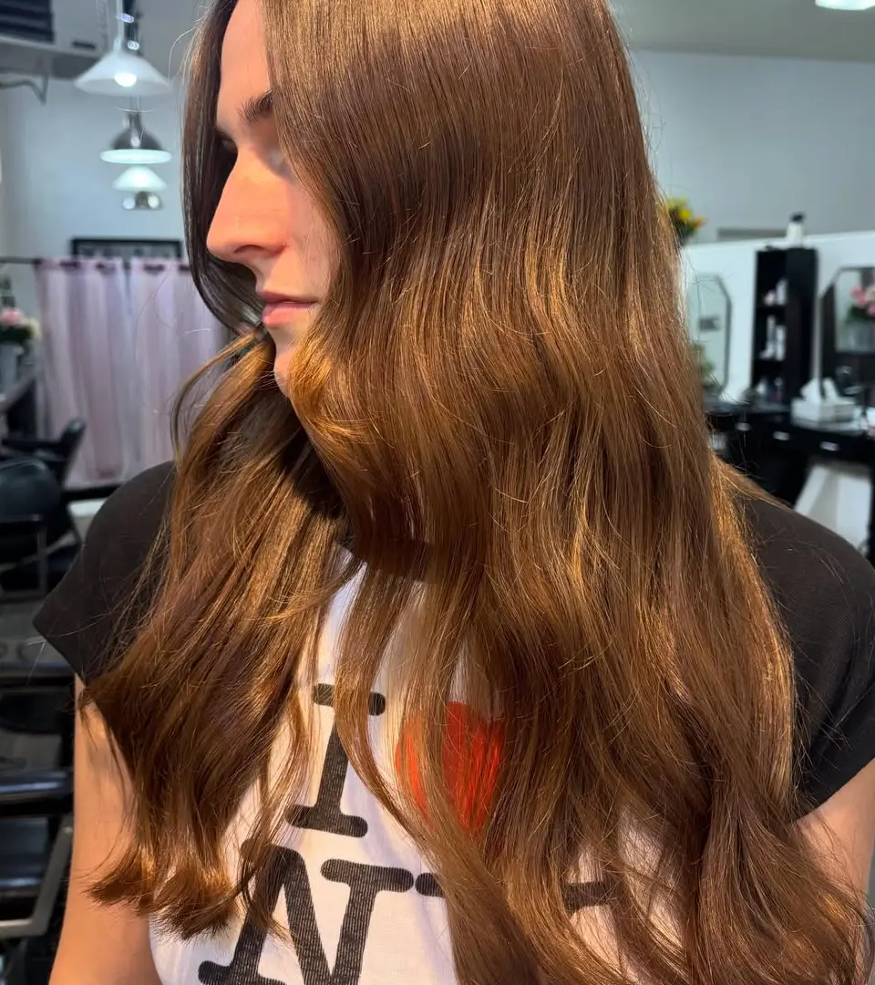 Long glossy chestnut brown waves, side view in the salon